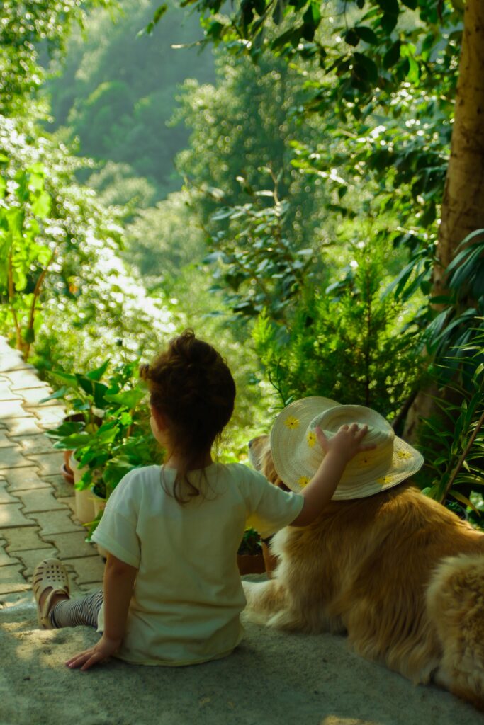 A child and dog enjoying a peaceful moment in a lush garden in Ardeşen, Türkiye.